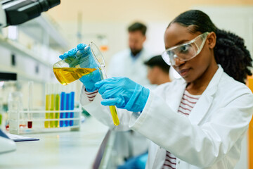 Wall Mural - Black female chemist working on research in laboratory.