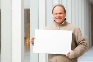 Sticker - Portrait of a smiling senior man holding a blank sheet of paper