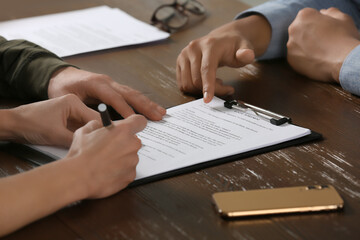 Canvas Print - Notary working with couple at wooden table, closeup