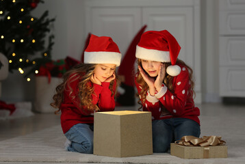 Wall Mural - Cute little girls with Christmas gift at home. Magic atmosphere