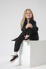 Wall Mural - Studio portrait of beautiful little girl in black and white outfit white background	
