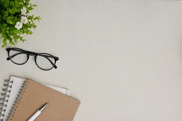 Wall Mural - Top view of a grey workspace background with copy space, eyeglasses, books, pen