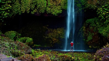 Wall Mural - Travel people explore beautiful waterfall Bali Pucak Manik hidden in tropical rainforest jungle on nature background Bali, Indonesia 4K