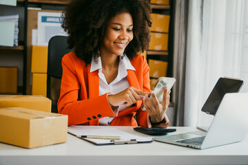 Wall Mural - African American business woman working at warehouse preparing SME package box for delivery at small business home office.