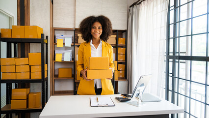 Wall Mural - African American business woman working at warehouse preparing SME package box for delivery at small business home office.