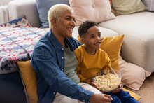 African American Mother And Son Streaming A Movie At Home Eating Popcorn