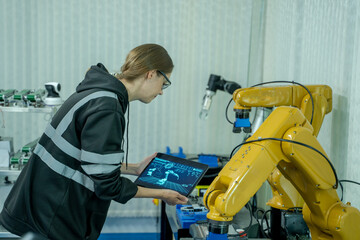 Aufkleber - Engineer using laptop for programming modern robot arm in automated manufacturing industry,Modern Equipment and New Era in Computer Science and Robotics Industry Concept.