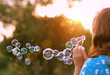 abstract blurred sunny natural background with girl blowing soap bubbles outdoor. dreaming, harmony peaceful atmosphere. Happy childhood concept. template for design