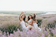 Group of happy cheerful young women enjoy summer picnic in the lavender field and take selfie. Friendship concept.