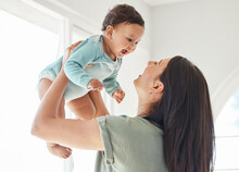 Mother Holding Laughing Baby In Home For Love, Care And Quality Time Together To Nurture Childhood Development. Happy Mom, Carrying And Playing With Infant Girl Kid For Support, Happiness And Fun