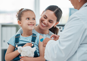 Girl, mom and doctor with vaccine injection, cotton ball and flu shot on arm for disease or covid prevention in hospital. Woman, nurse and child with pediatrician help with bandaid, teddy or health