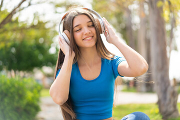 Wall Mural - Teenager girl at outdoors listening music