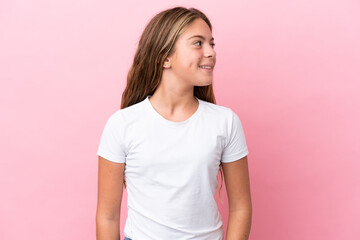 Wall Mural - Little caucasian girl isolated on pink background looking to the side and smiling