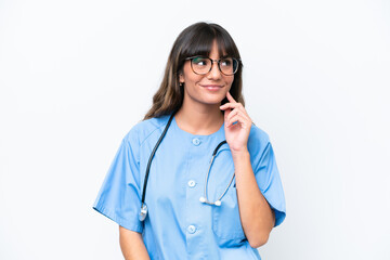 Wall Mural - Young caucasian nurse woman isolated on white background thinking an idea while looking up