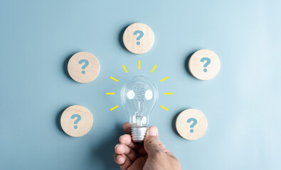 Aufkleber - Hand holding Light Bulb which among Question icon. Target solution target, successful business and thinking solution strategy concept.