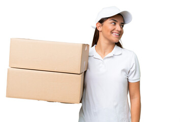 Wall Mural - Delivery caucasian woman holding boxes isolated on green chroma background looking side