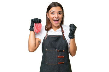 Poster - Butcher woman wearing an apron and serving fresh cut meat isolated on green chroma background celebrating a victory in winner position