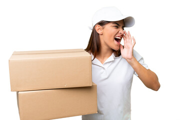 Wall Mural - Delivery caucasian woman holding boxes isolated on green chroma background shouting with mouth wide open to the side