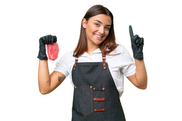 Poster - Butcher woman wearing an apron and serving fresh cut meat isolated on green chroma background showing and lifting a finger in sign of the best