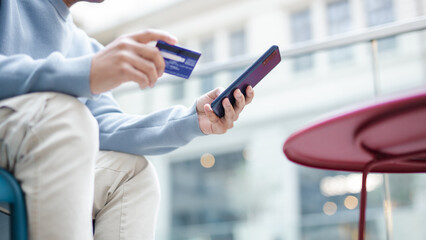 The man makes a purchase on the Internet on the smartphone with credit card, online payment, online purchases, electronic commerce, internet banking, money spending