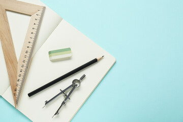 Wall Mural - Different rulers, pencil, compass and notebook on turquoise background, flat lay. Space for text