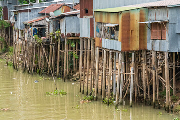 Wall Mural - Rustic tin housing raised up on high poles above a river at Chau Doc in Vietnam