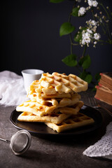 Wall Mural - Pile of Fresh Homemade soft waffles served on dark plate.