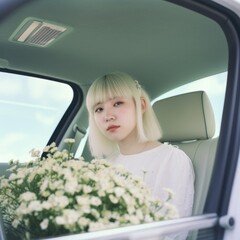 Wall Mural - Young woman with white hair sitting in the car surrounded by flowers