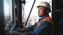 Construction Worker Operator Of Asian Appearance In The Cab Of A Construction Crane. Generative AI
