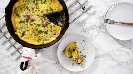 Canvas Print - Flat lay. Slicing freshly baked spinach and ham frittata in cast iron skillet.