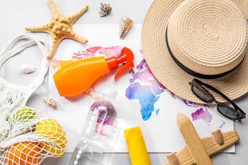 Wall Mural - Composition with world map, sunscreen cream, bottle of water and wooden plane on grey background