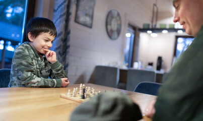 Wall Mural - Military man in olive uniform playing chess and having fun with his little son at home