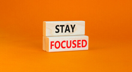 Stay focused symbol. Concept words Stay focused on wooden blocks on a beautiful orange table orange background. Business, support, motivation, psychological and stay focused concept. Copy space.