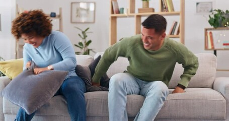 Sticker - Pillow fight, happy couple and fun in living room for love, silly game and energy at home. Cushion, fighting and excited man being playful with young woman, partner and laughing together on couch