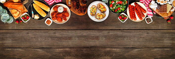 Leinwandbilder - Summer BBQ food top border over a dark wood banner background. Assorted grilled meats, potatoes, vegetable dishes and smores platter. Overhead view.