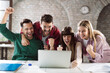 © Goran - Cheerful entrepreneurs celebrating their success while using computer in the office