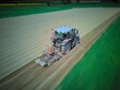 traktor orający pole. Zdjęcie z rozmyciem ruchu. Na pługu siedzi rolnik