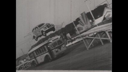 Wall Mural - United Kingdom 1950, Daredevil Jump: Stuntman Leaps Over Bus with Vintage Car in the 1950s