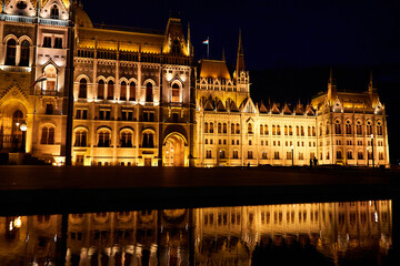 Wall Mural - A fabulous nighttime photo of the illuminated facade of the parliament building in Budapest, reflected in the water