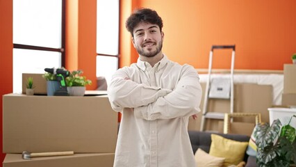 Wall Mural - Young hispanic man smiling confident standing with arms crossed gesture at new home