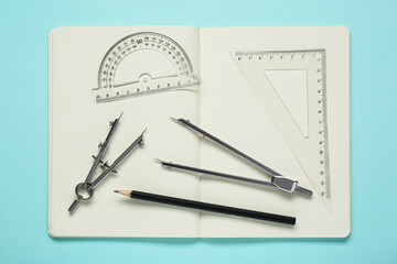 Wall Mural - Different rulers, pencils, compasses and notebook on turquoise background, flat lay