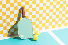 Pickleball Paddle And Ball Against Checkered Wall