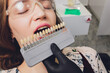 Close up portrait of Young women in dentist chair, Check and select the color of the teeth. Dentist makes the process of treatment in dental clinic office.Dentist.