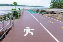 There Are 2 Bicycle Roads Next To The River. The Pedestrian And Bicycle Lanes Have The Symbols Of People And Bicycles.