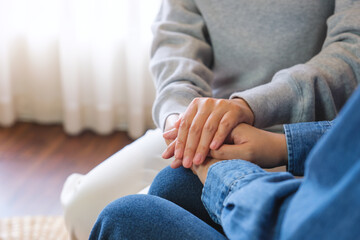 Wall Mural - Closeup image of a couple women holding each other hands for comfort and sympathy