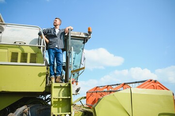 Farmer controls the combine harvester.