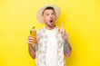 canvas print picture - Young caucasian man holding a cocktail isolated on yellow background thinking an idea pointing the finger up