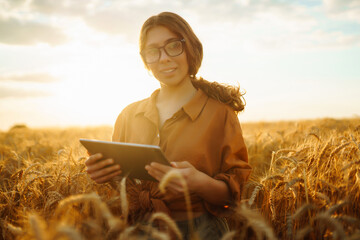 Farmer woman in a wheat field touches the ears of barley. Rich harvest concept.