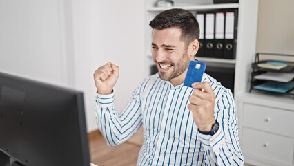 Poster - Young hispanic man business worker shopping with credit card and computer with winner expression at office