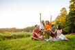 © maxbelchenko - Group of young people gathered in garden for picnic. Friends have fun and  drink beer. Vacation, picnic, friendship or holliday concept.